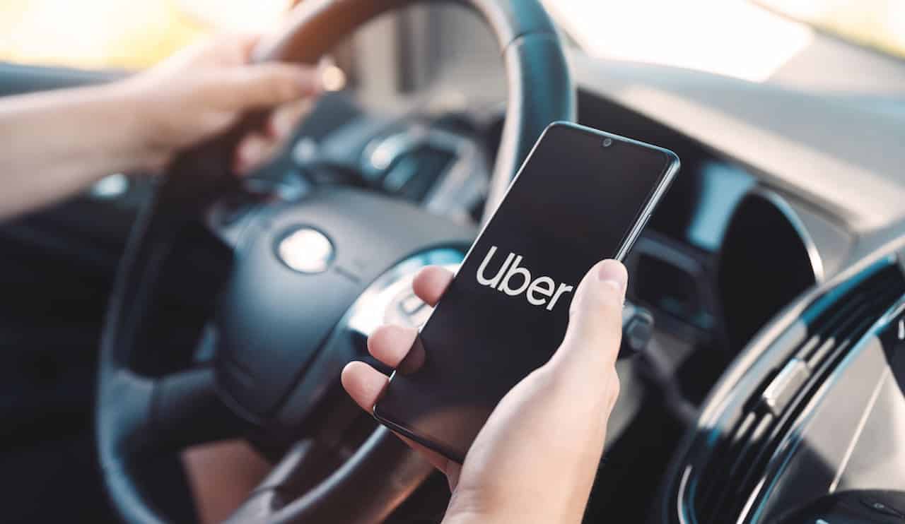 Motorista Uber segurando o celular na mão