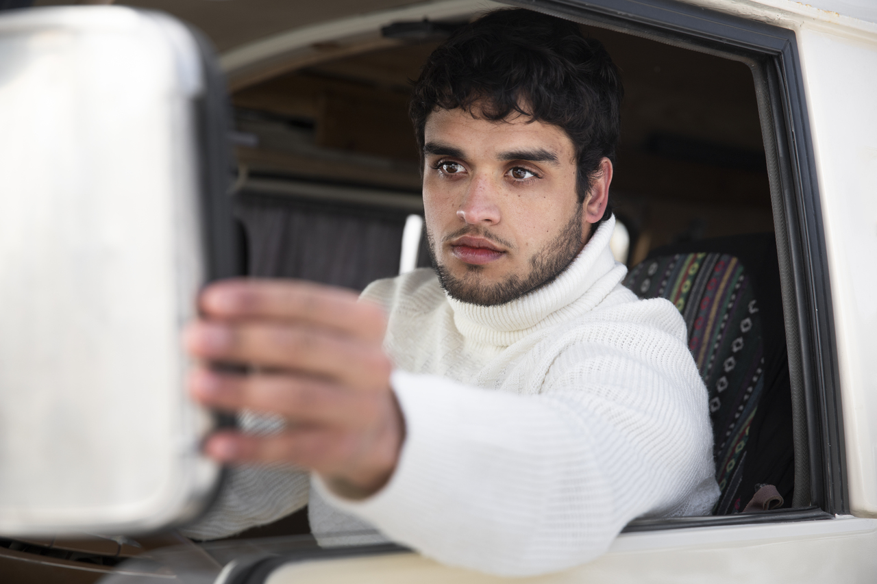 Motorista ajusta se retrovisor externo 