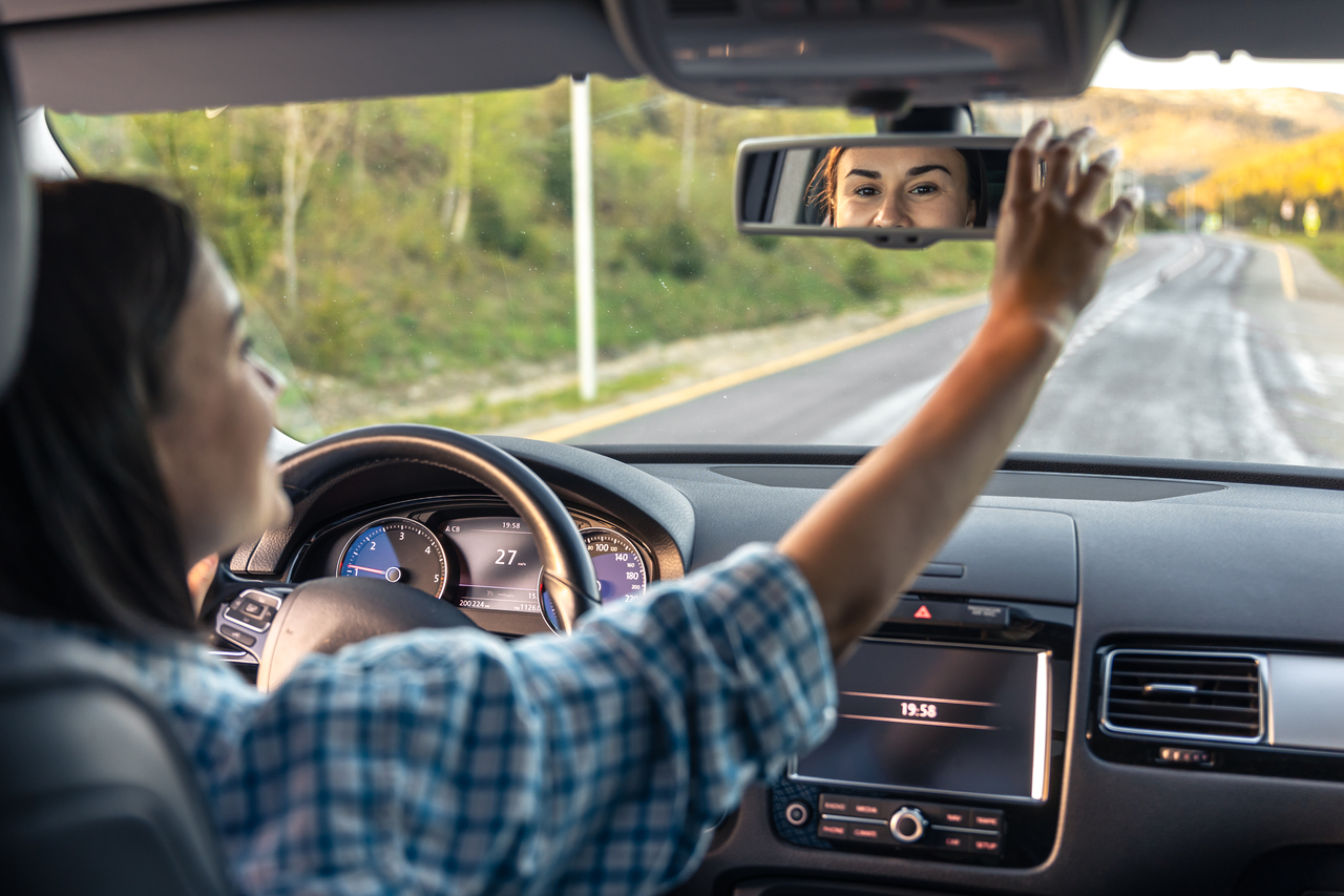 Motorista ajusta se retrovisor interno 